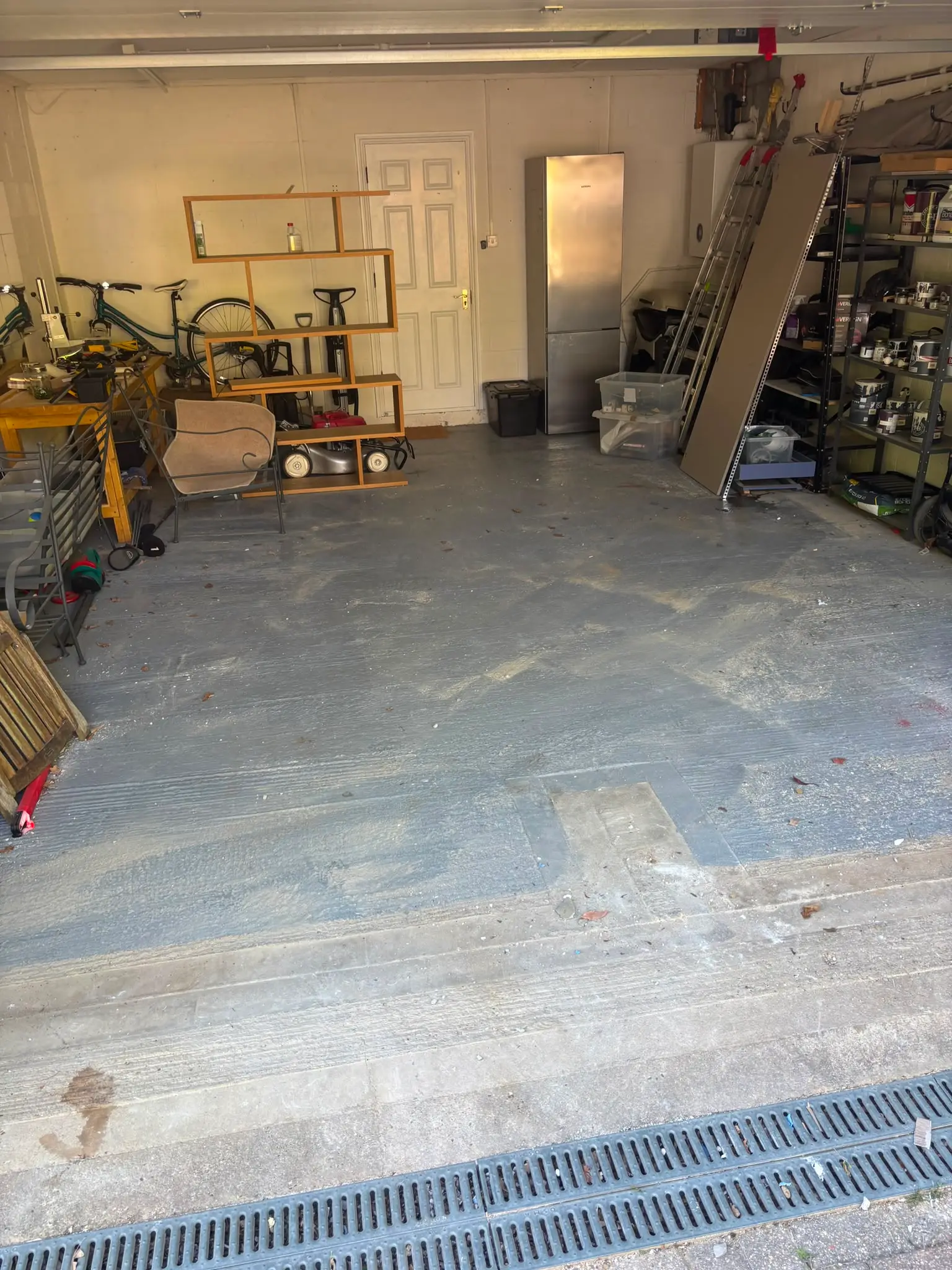 The same garage floor swept clear after the bathroom strip-out waste was loaded and taken away.