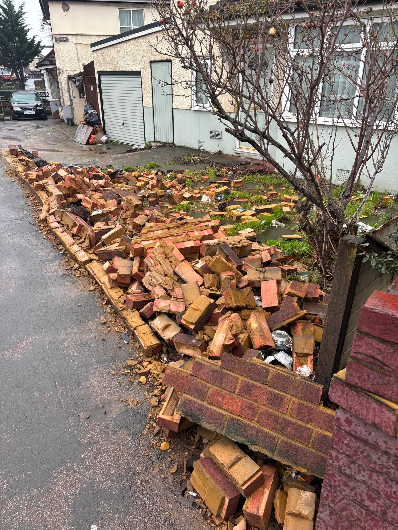 Bricks and renovation materials collected beside a residential property.