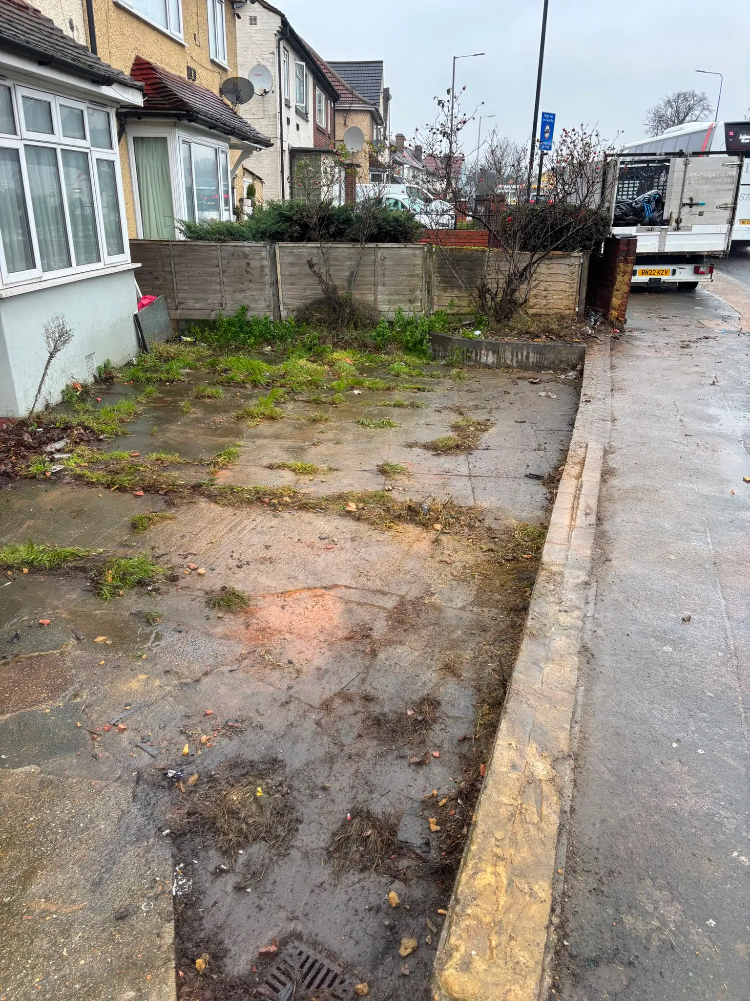 Cleared exterior area beside a residential property after waste removal.