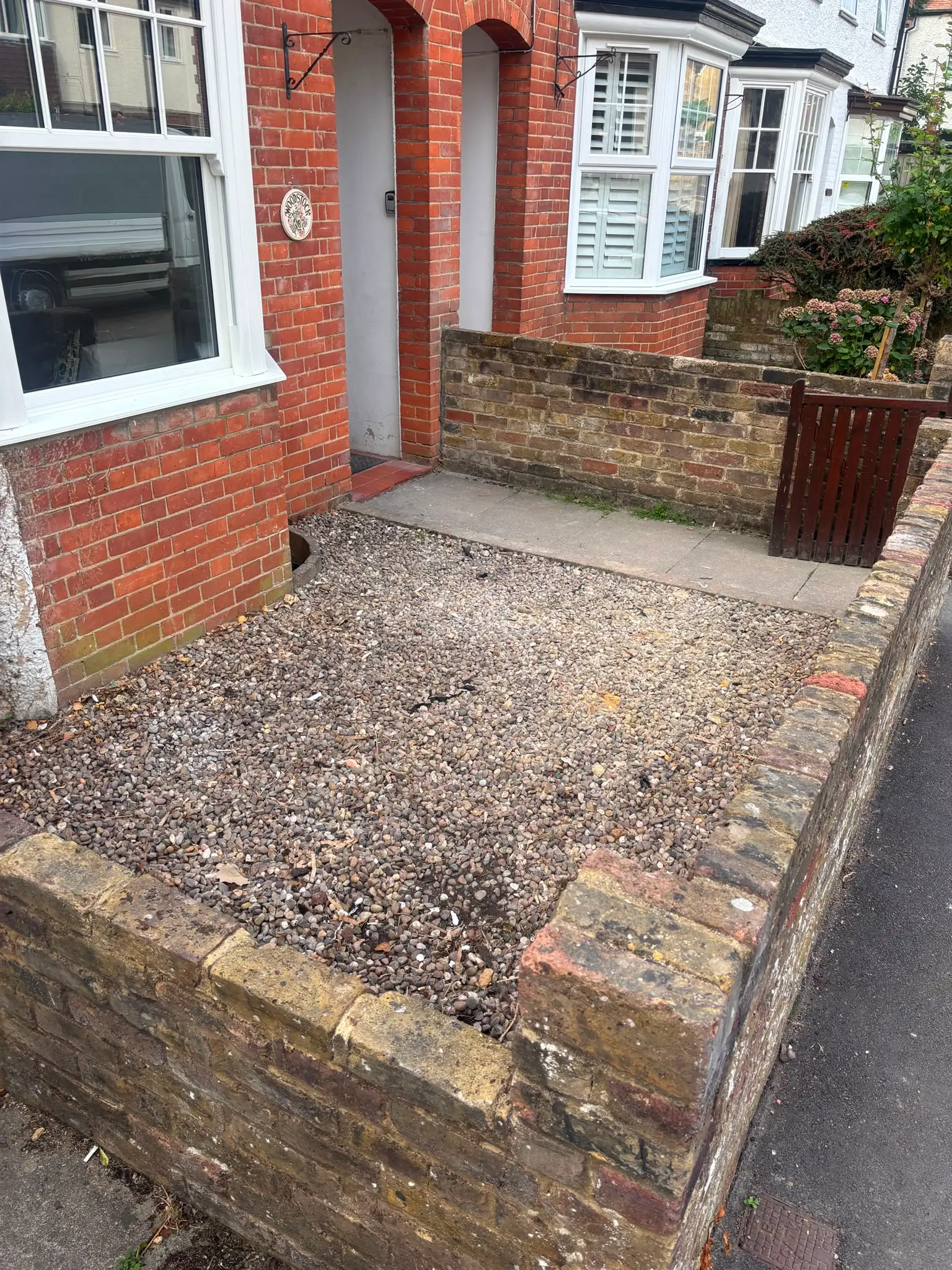 The same front garden cleared back to gravel after the cardboard and packaging waste was removed.