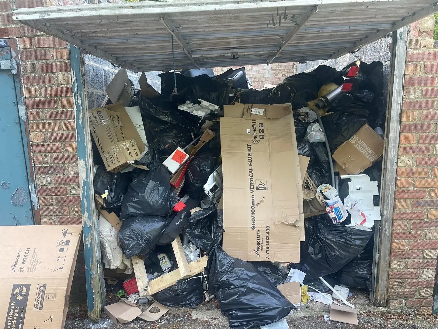 Garage full of bagged waste before clearance Garage filled with bagged household waste and cardboard before clearance.