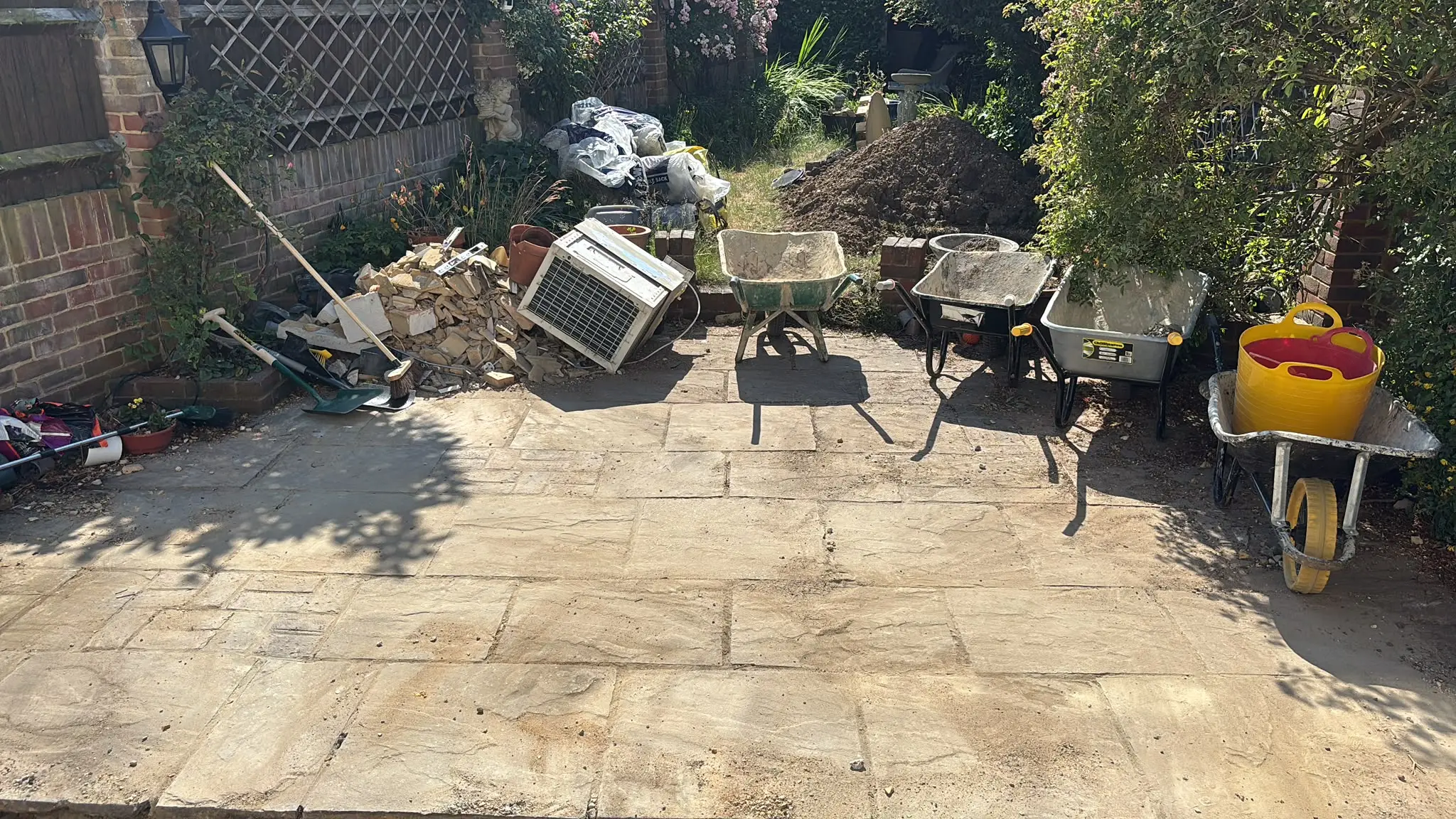 Garden renovation area with rubble and materials gathered for clearance.