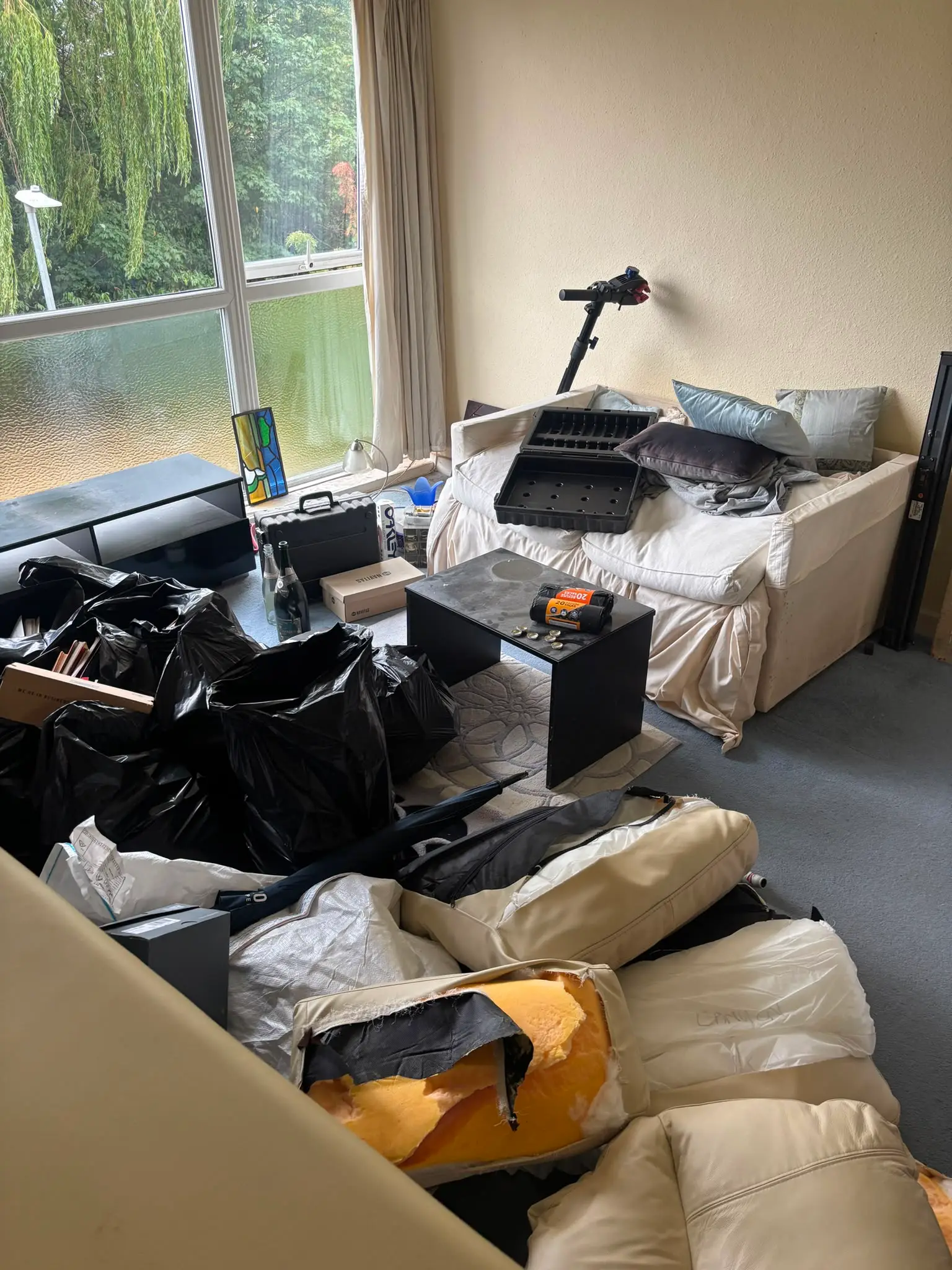 Household items and bags gathered inside a property before removal.