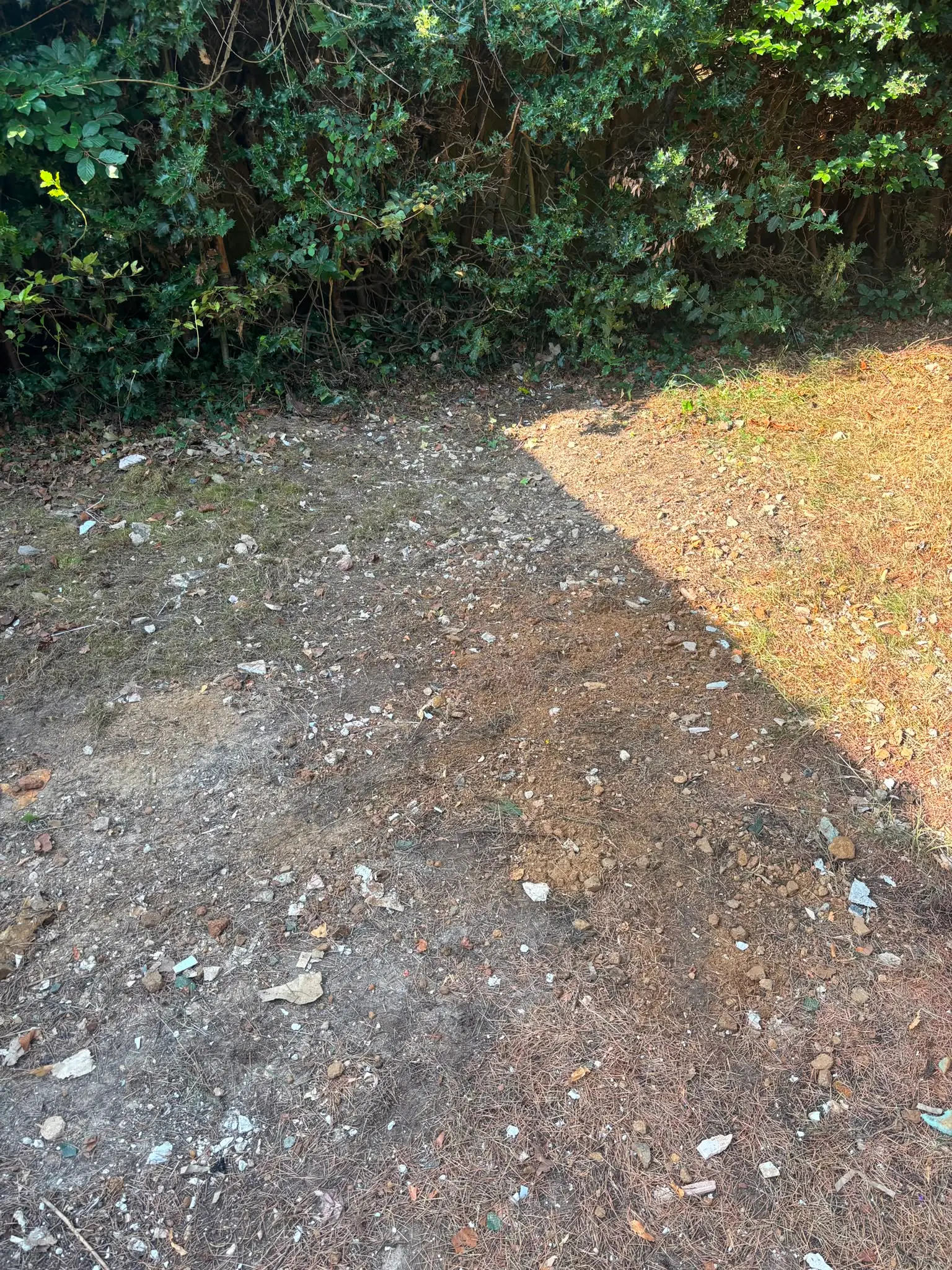 The same strip of garden cleared, with only brick dust left where the pile stood.