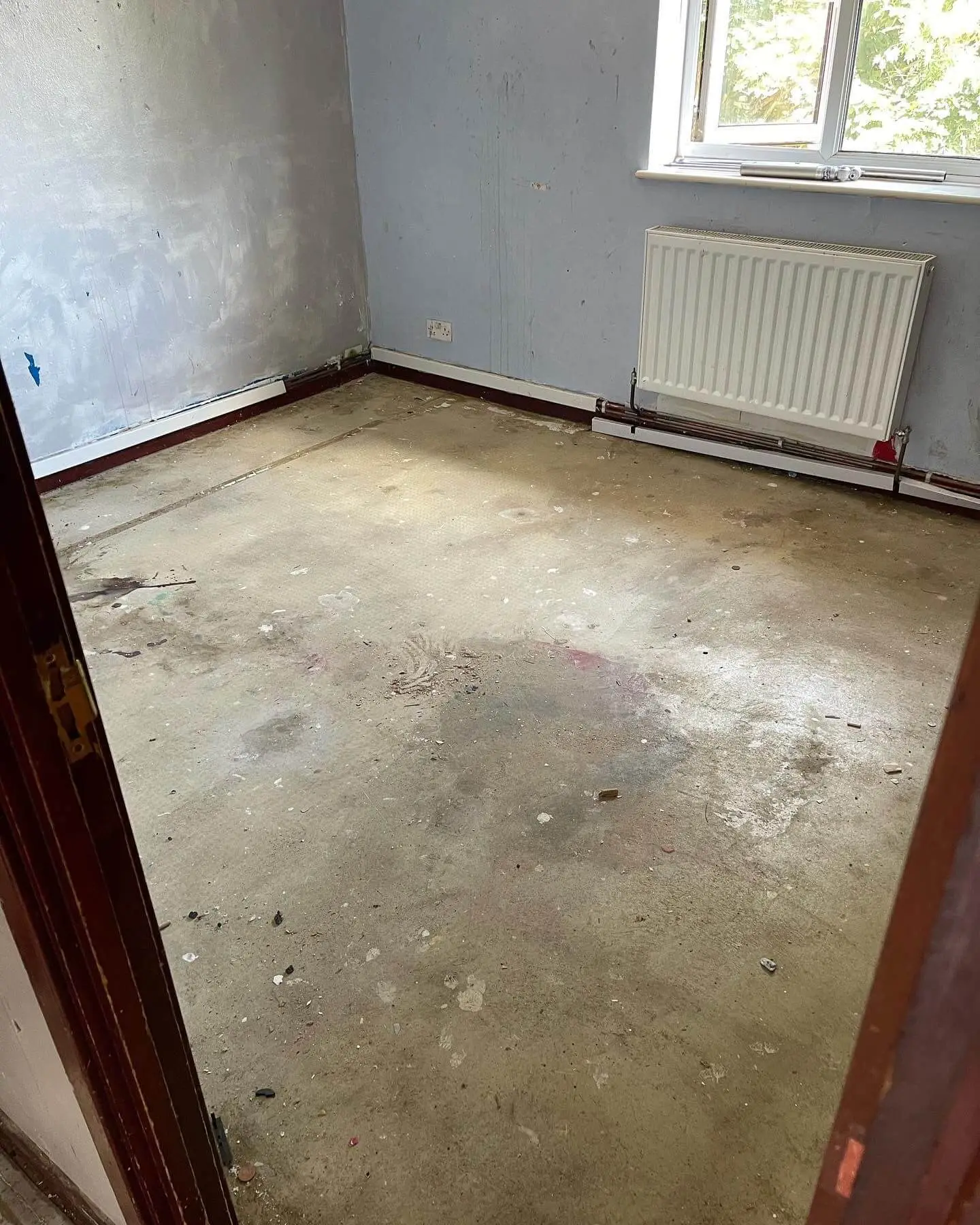 Empty residential room after dismantled units, flooring and refurbishment waste have been removed.