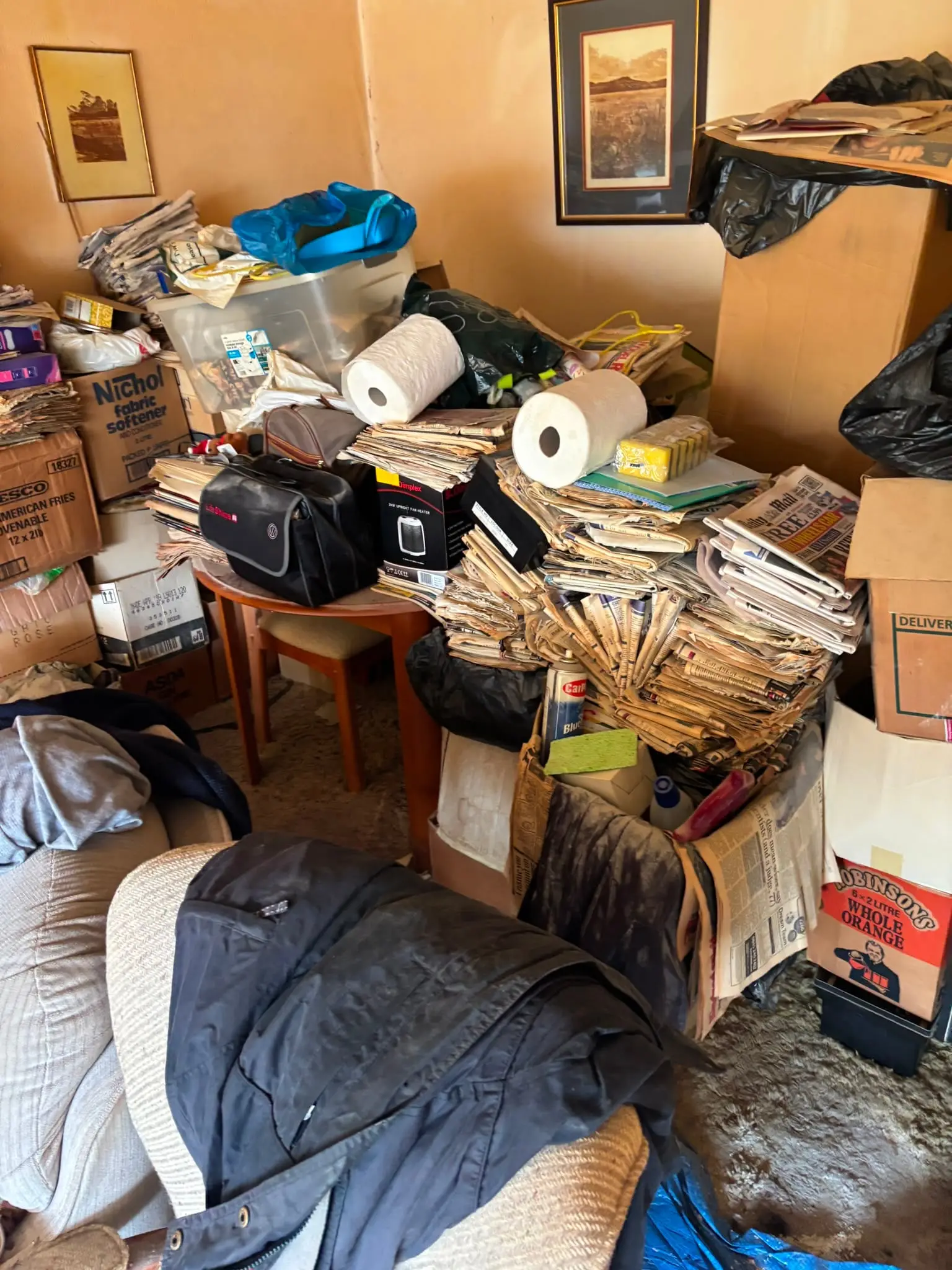 Room full of furniture and boxes before a property clearance.